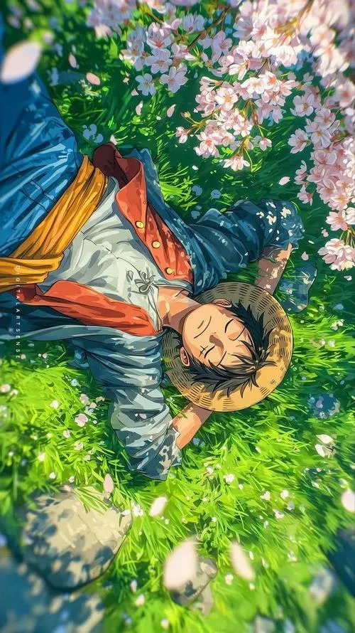 Ảnh nền Luffy nằm trên cỏ, hoa rơi quanh tóc, tông xanh mát cho màn hình dịu.