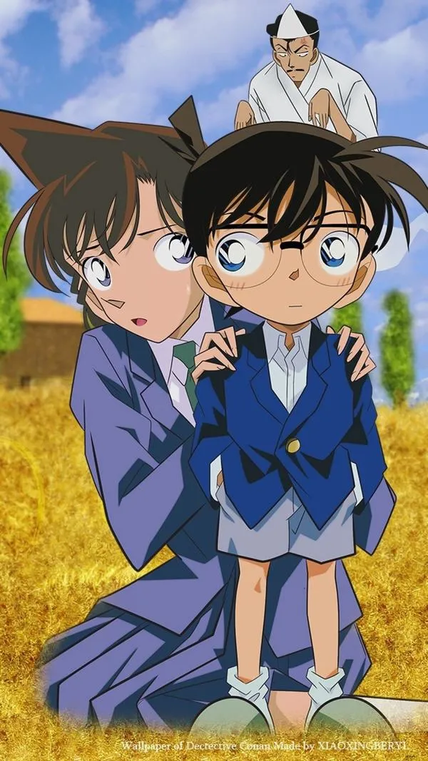 Hình anime Ran đứng cạnh Conan trong bộ suit xanh, ánh mắt lo lắng, bố cục trung tâm, làm ảnh bìa