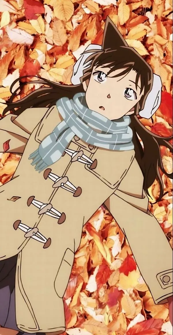 Hình Ran Mori áo khoác dày giữa lá thu cam, mắt to trong trẻo, tông ấm, hợp làm hình nền