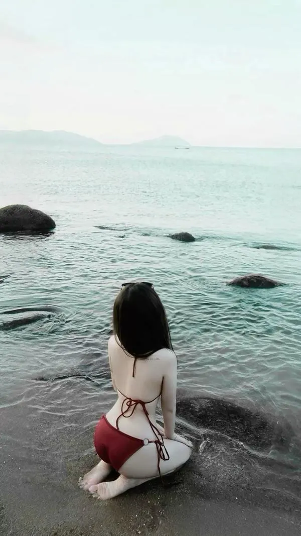 Hậu cảnh chân trời và mây mỏng, cô gái che mặt, bikini tối giản, da bắt nắng, thần thái lạnh cuốn.