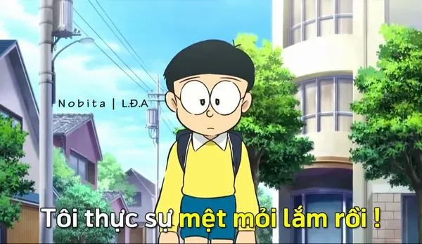 Nobita đứng một mình giữa phố, mắt nhìn xuống, cảm giác mệt mỏi và cô đơn bủa vây.