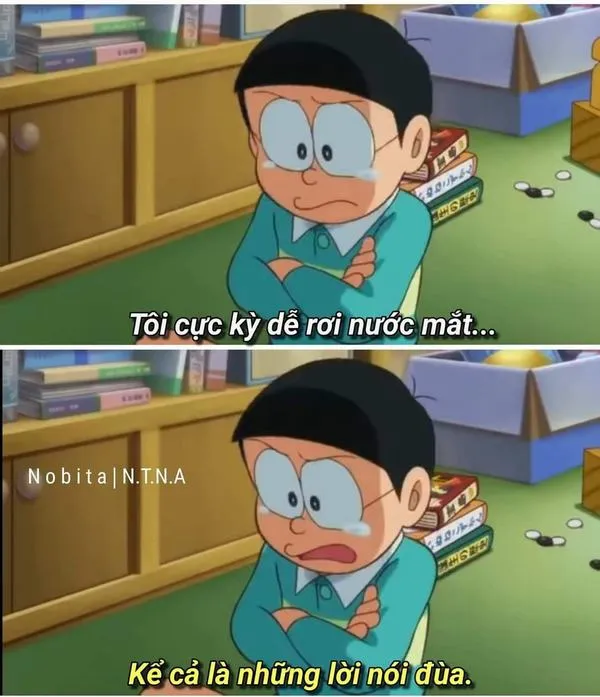 Nobita ngồi bệt trong phòng, quay lưng vào tường, cô đơn rõ rệt trong ánh sáng nhạt.