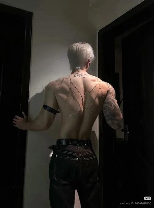 Quay lưng ở hành lang, cơ lưng nổi, phong cách che mặt tạo cảm giác bí ẩn.