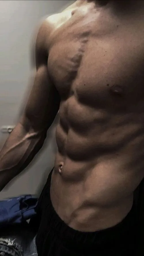 Cận bụng và ngực, mồ hôi lấm tấm tạo cảm giác vừa tập xong, body săn chắc rõ ràng.