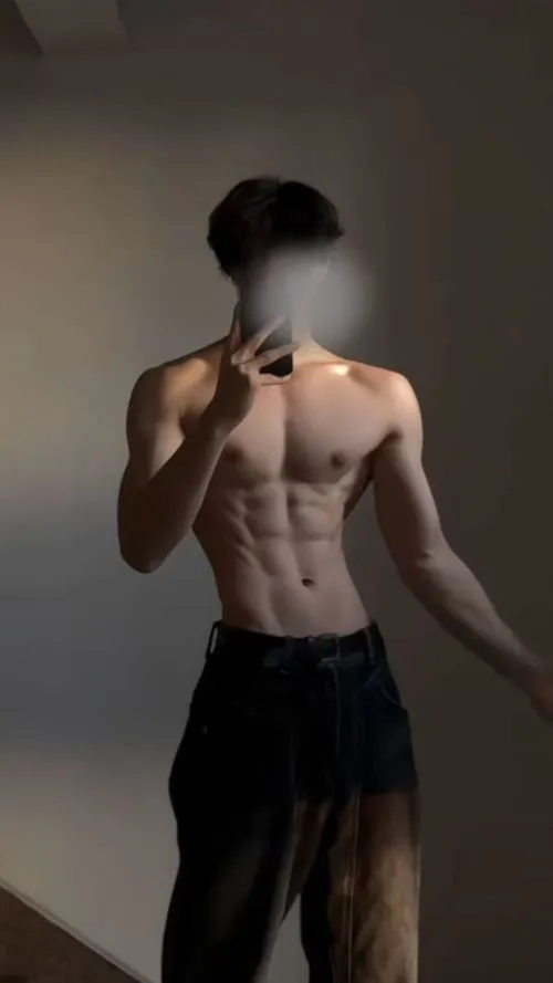 Tạo dáng trước gương, góc chụp tôn chữ V và nét khối cơ bụng rõ ràng.