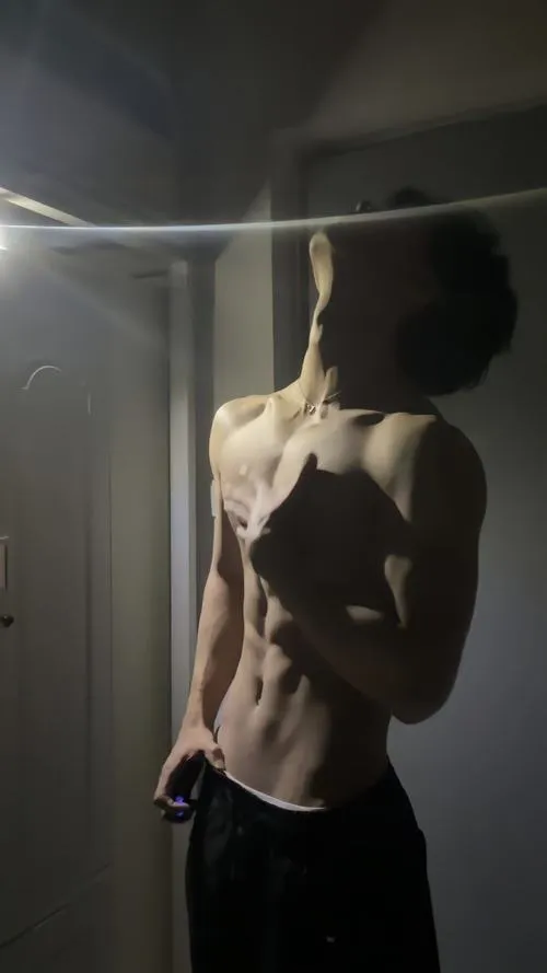 Chụp nghiêng dưới ánh cửa sổ, cơ bụng nổi khối, dáng mảnh mà vẫn khỏe khoắn.