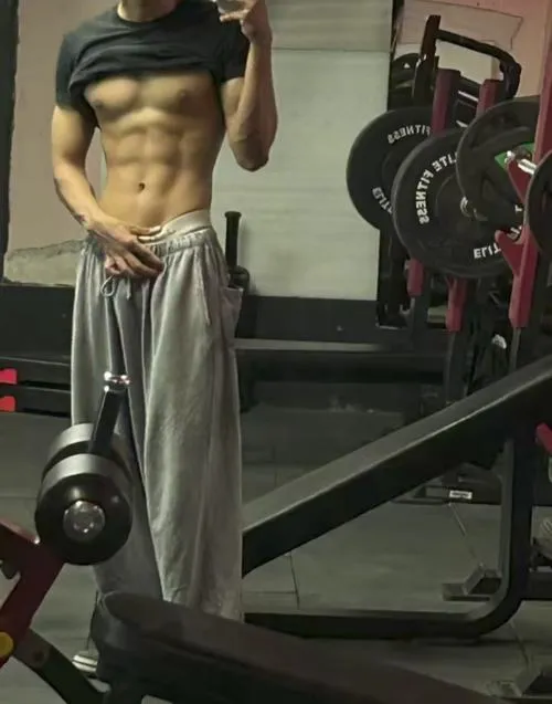 Cận cảnh body trên máy tập, sáu múi rõ, phòng gym nền tối nhìn cực lực