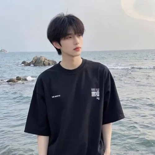 Đứng bên biển, áo thun đen, bối cảnh thoáng, vibe dịu mắt và tự nhiên