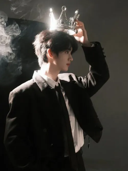 Bộ vest tối, ánh sáng mạnh phía sau, dáng đứng ngầu nhưng vẫn gần gũi