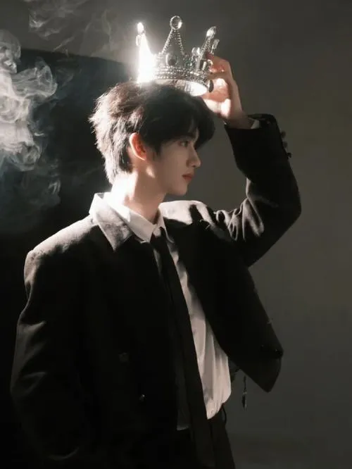 Nam thần lạnh lùng trong khói mờ, suit tối, ánh đèn hắt làm viền tóc nổi bật.