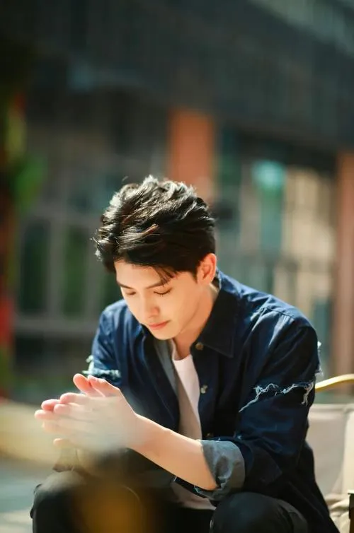 Trai đẹp Việt Nam ngồi trầm tư, tông màu dịu, góc chụp ngang tạo cảm giác sâu.