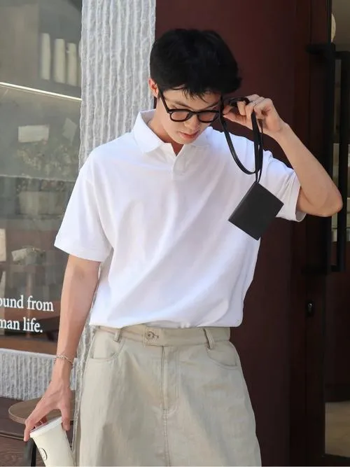Trai đẹp Việt Nam mặc áo trắng rộng, đeo kính, phong cách chụp ảnh đường phố giản dị.