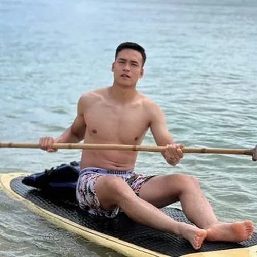 Ảnh trai Việt cuốn hút ngồi bên biển, bối cảnh Việt Nam thoáng đãng, dáng người rắn rỏi.