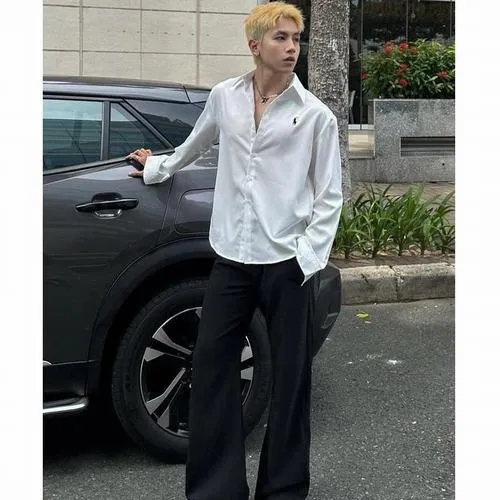 Trai đẹp Việt Nam đứng giữa phố xá, góc chụp thấp, cảm giác cao ráo và mạnh.