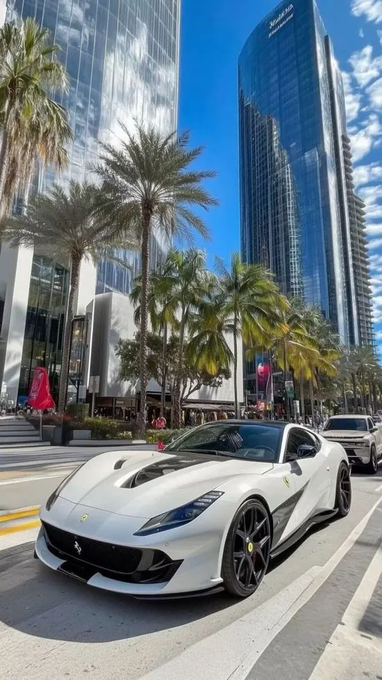 Mẫu xe trắng mui thấp đứng giữa đại lộ đầy nắng, hàng cọ và cao ốc xanh phía sau khiến wallpaper xe cộ Ultra HD hợp kiểu màn hình dọc hiện đại