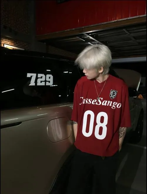 Sau cơn mưa, người mẫu trẻ buộc lại dây giày trên sân thượng, cạnh vũng nước phản chiếu biển quảng cáo thành phố.