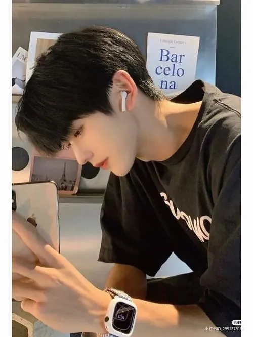 Một người mẫu nam bước qua sân khấu phủ khói, áo choàng đỏ chuyển động theo nhịp chân, ánh sáng phòng chụp hắt viền quanh mái tóc.