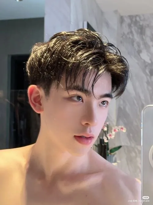 Sớm tinh mơ trên thuyền đánh cá, người thanh niên kéo lưới trong áo gió xanh, mái tóc ướt và nụ cười khỏe khoắn nổi bật giữa biển.