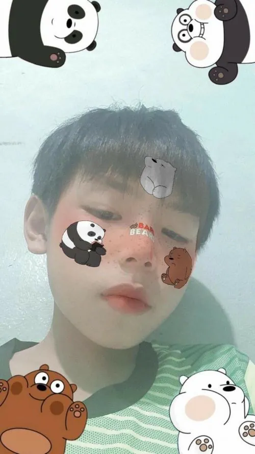 Cận mặt nam sinh dùng sticker gấu trúc, đôi mắt lim dim và nền sáng làm khung hình trông đáng yêu tự nhiên.