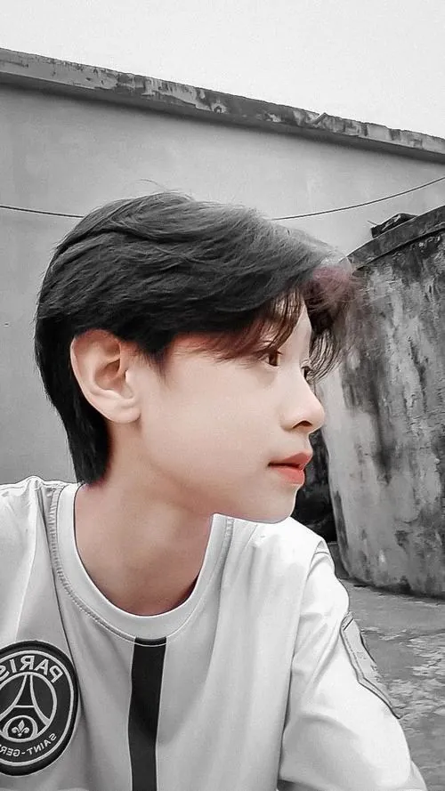 Chàng trai tóc đen chụp góc nghiêng bên nền sáng, sống mũi và gương mặt thư sinh hiện lên rất nhẹ nhàng.
