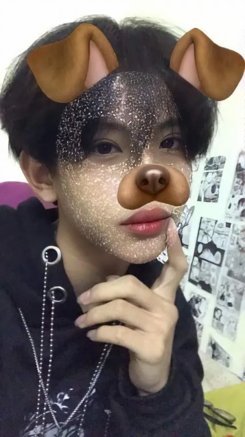 Ảnh trai đẹp k9 dùng hiệu ứng tai cún khi selfie, áo tối màu và ánh nhìn nghiêng tạo nét tinh nghịch tuổi học trò.
