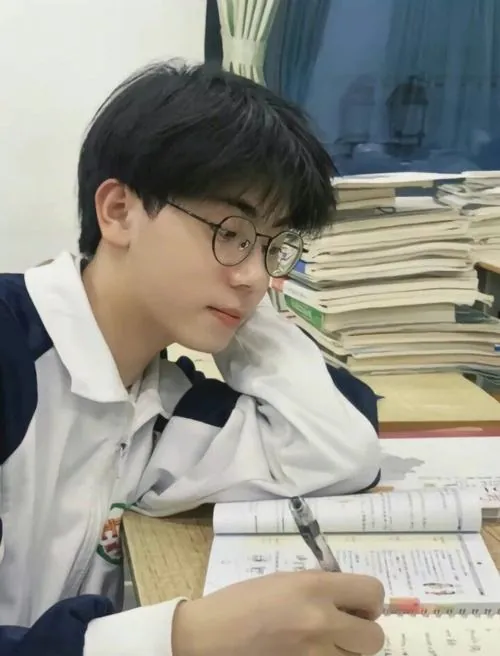Trước cổng điểm thi tốt nghiệp trung học phổ thông, chàng trai kiểm tra thẻ dự thi, gương mặt bình tĩnh giữa dòng người đông.