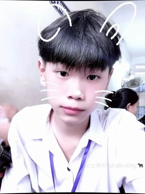 Nam sinh áo sơ mi trắng dùng filter tai mèo, gương mặt sáng và tóc mái dày tạo cảm giác dễ thương.