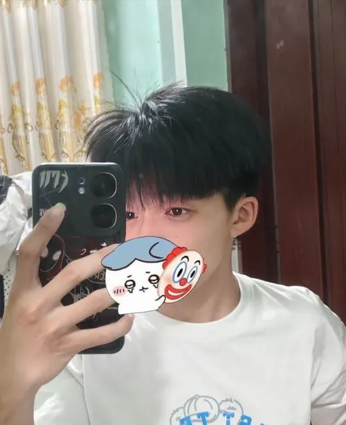Tại khu để xe của trường, học sinh nam ngồi trên xe đạp và hạ tấm kính mũ bảo hiểm che khuất gương mặt.