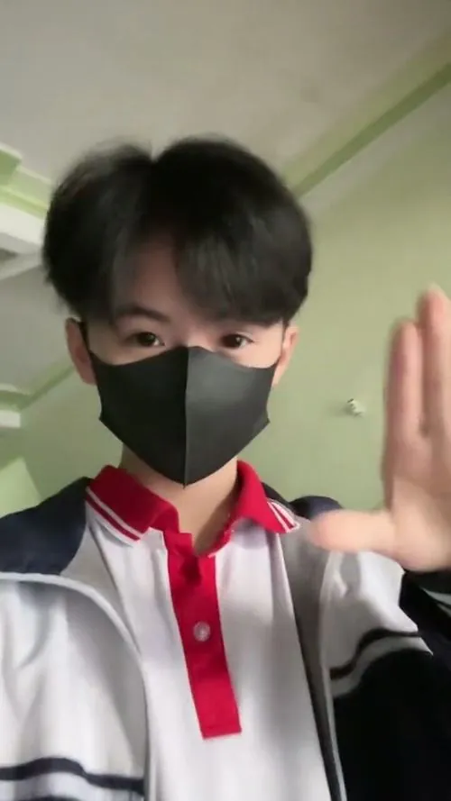 Buổi diễn văn nghệ chưa bắt đầu, nam sinh mặc áo sơ mi đứng sau tấm rèm sân khấu, bóng đổ che phần mắt tự nhiên.