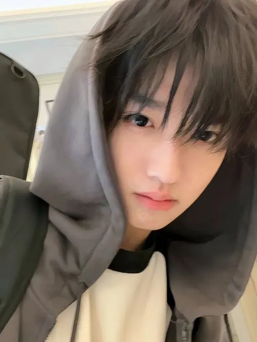 Ảnh trai đẹp k11 mặc hoodie trắng chụp cận mặt, mái tóc ướt rũ xuống trán và ánh nhìn bình yên rất hợp vibe thanh xuân.
