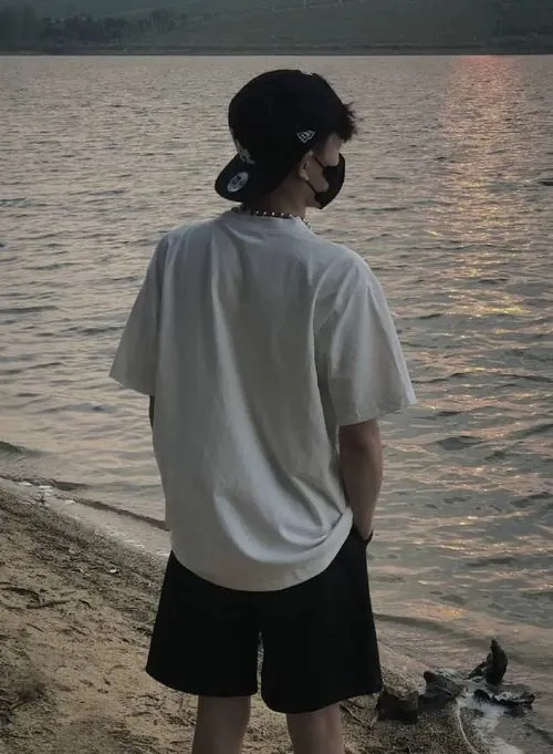 Khung hình đen trắng thể hiện chàng trai mặc áo phông ôm sát nghiêng đầu sang bên, mái tóc rủ xuống che đi đôi mắt sâu lắng.
