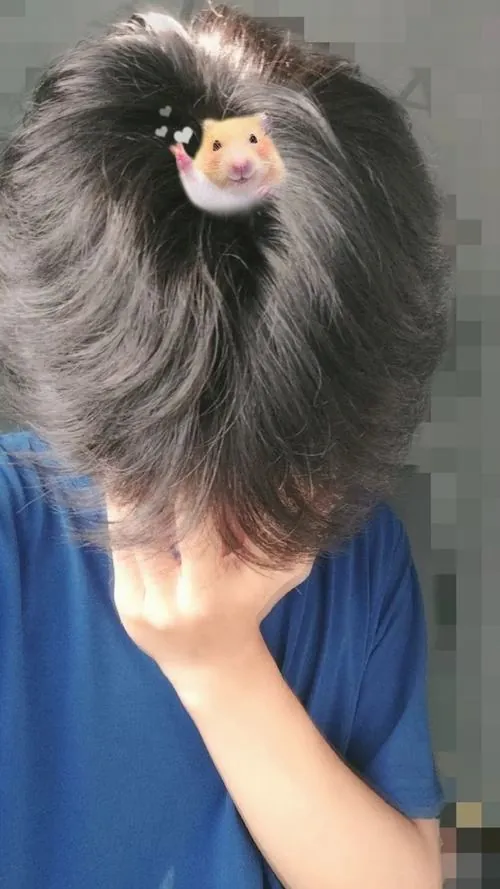 Khung hình cận cảnh góc nhìn từ trên xuống ghi lại khoảnh khắc chàng trai cúi đầu gục xuống bàn, đôi bàn tay đan nhẹ che lấy gương mặt giữa tông màu xám trầm tĩnh.
