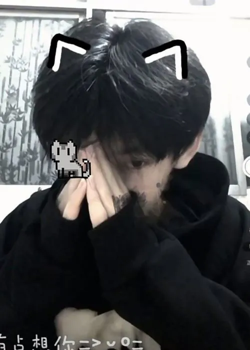 Tấm ảnh chụp ngẫu hứng chàng trai khoác áo hoodie đen chụm hai bàn tay che miệng, thêm biểu cảm icon tai mèo hóm hỉnh ngay trên mái tóc.