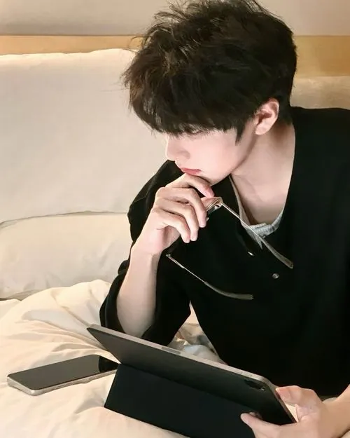 Chàng trai ngồi ở quán ăn lề đường lúc rạng sáng, lấy chiếc khẩu trang vải đen kéo lệch lên che một bên má khi chờ mỳ nóng.