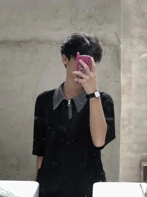 Chàng trai đứng bên khung cửa kính đẫm nước mưa, giơ bàn tay gầy chạm vào kính che đi ánh nhìn hướng ra khoảng không xám xịt.