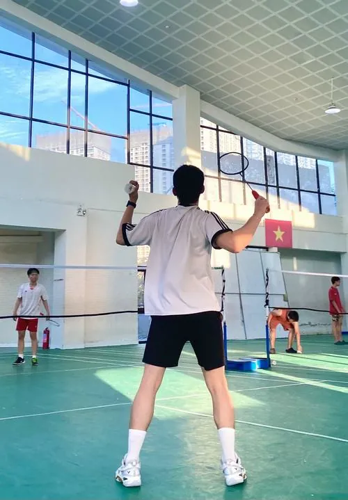 Góc quay từ phía sau ghi lại dáng lưng săn chắc của vận động viên nam đang sắn sàng giơ vợt chuẩn bị đón quả cầu.
